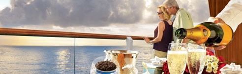 Couple enjoying champagne and caviar on their balc Couple enjoying champagne and caviar on their balcony.