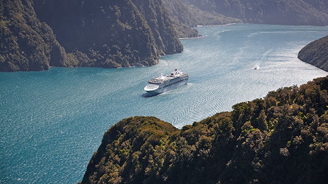 ship sailing through Fiordland National Park
