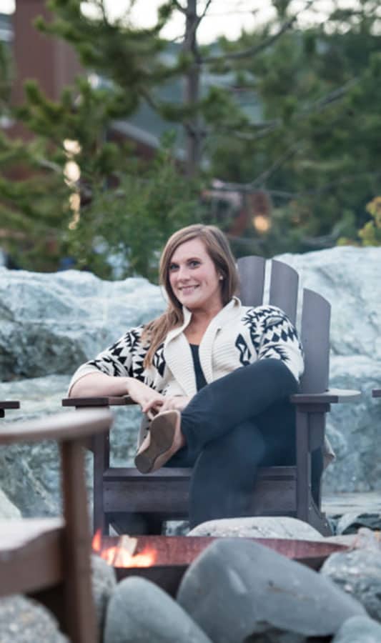 Guest enjoying sitting by outdoor firepit at Mt. Mckinley Princess Wilderness Lodge