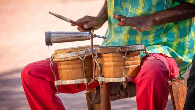 man sitting, playing timbales