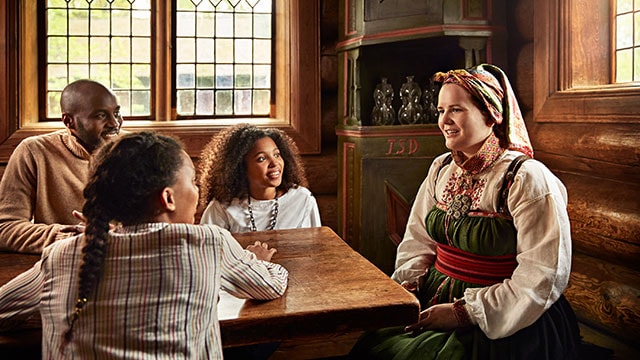 A family eagerly listen at a Norwegian cultural museum