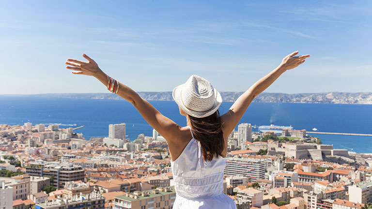 A woman raises her hands in the air on rooftop