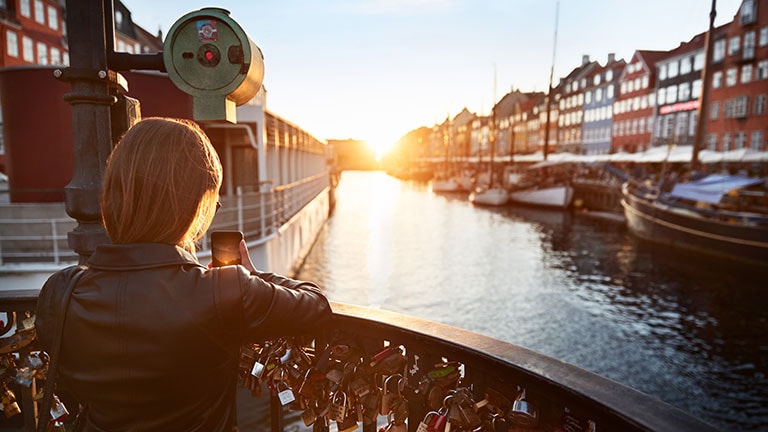 Taking a picture of the sun setting over a canal in Cophengagen, Denmark