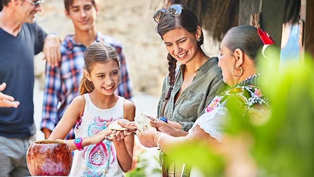 family learning how to make mexican pottery