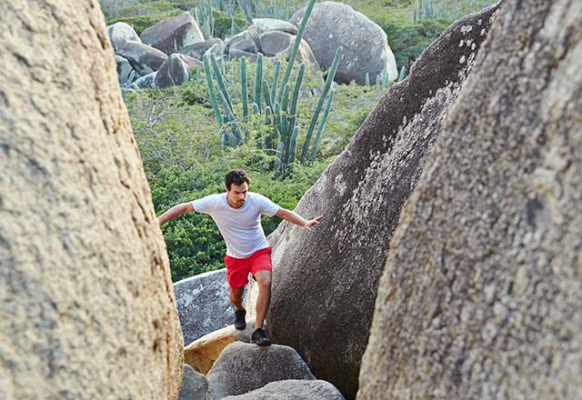 young man exploring the Ayo & Casibari Rock Formations in Aruba